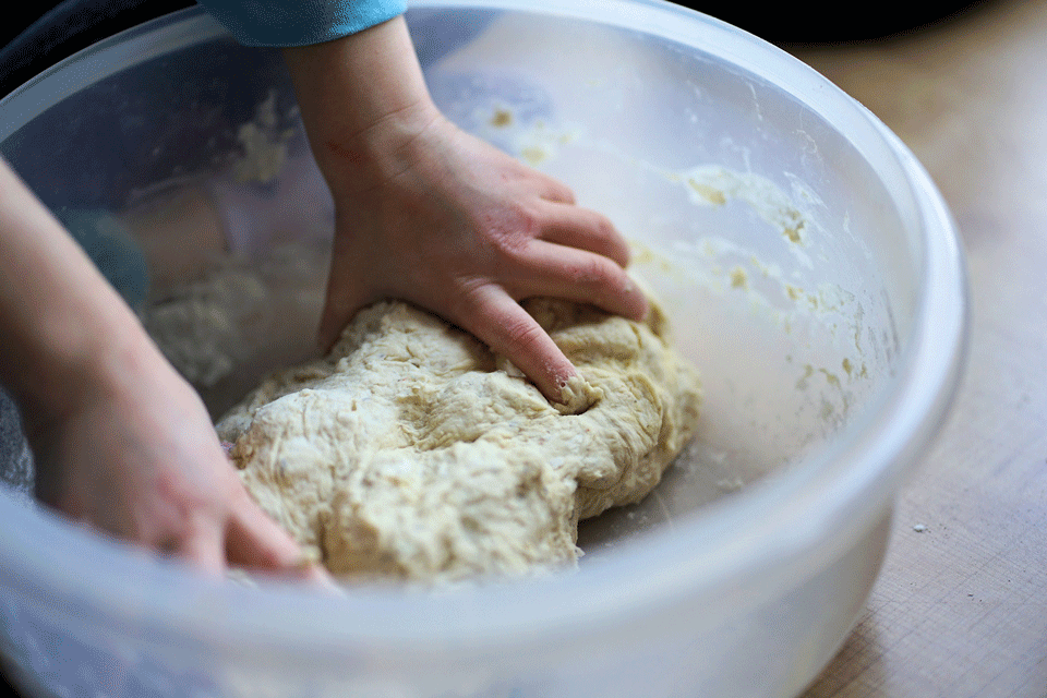 Child kneading dough in a bowl