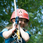 girl hanging on a rope on a rope course