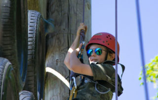Boy climbing a vertical obstacle course