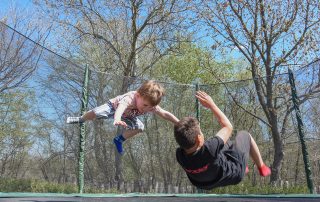 2 kids bouncing on a trampoline