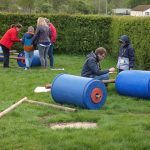 Families working together constructing rolling barrel buggies at the PPUK Be Curious Weekend 2019