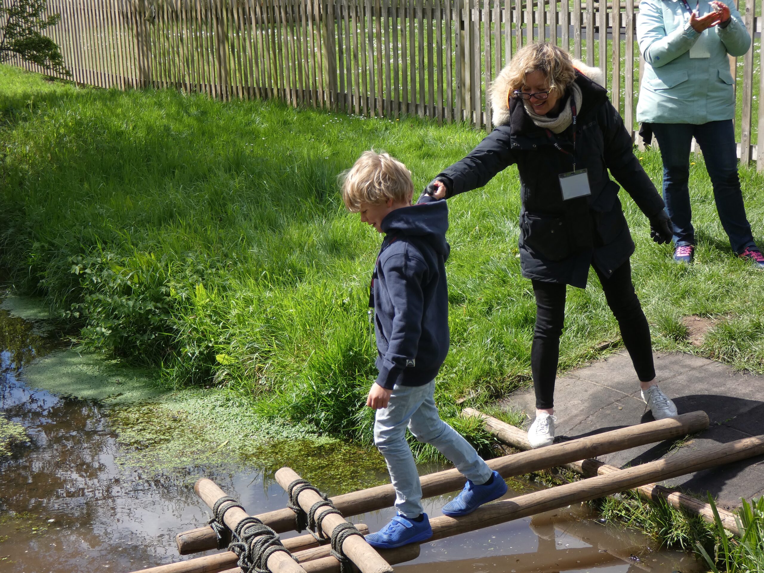 Child testing the bridge they built across a stream at the PPUK Be Curious Weekend 2019