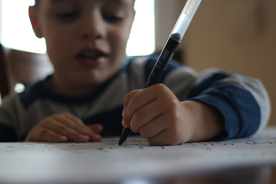 Boy writing with a pen