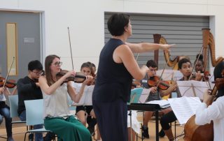 LPO Junior Artist: Overture Project - conductor and orchestra with participants playing music