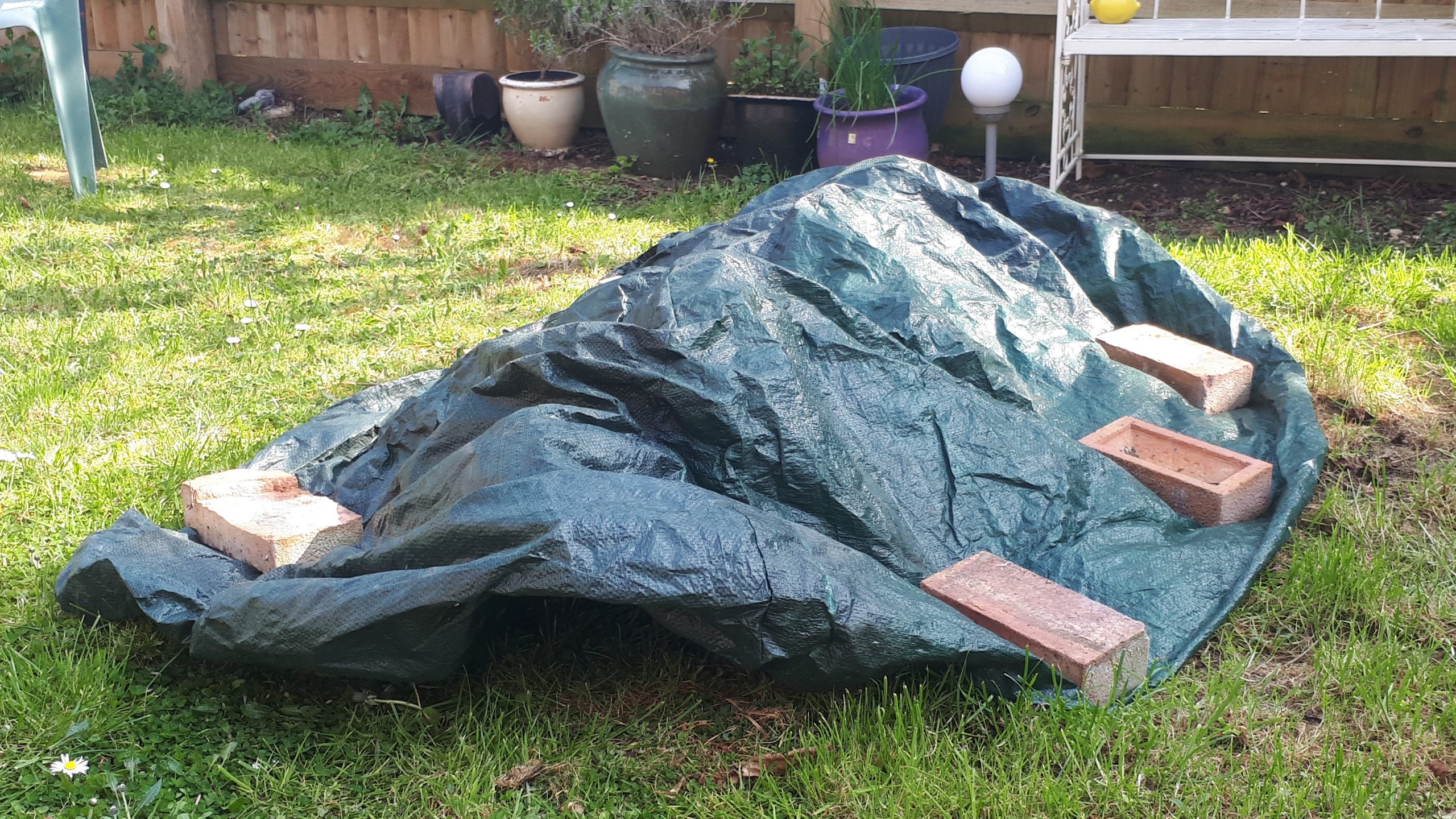 Tarpaulin with bricks holding down the sides to make a tunnel