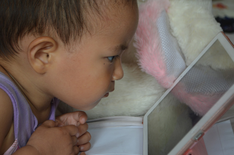 young girl staring at a computer screen