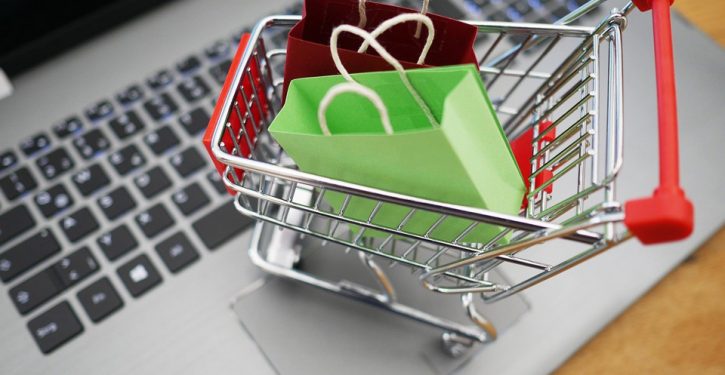 mini shopping cart with bags sitting on a computer keyboard