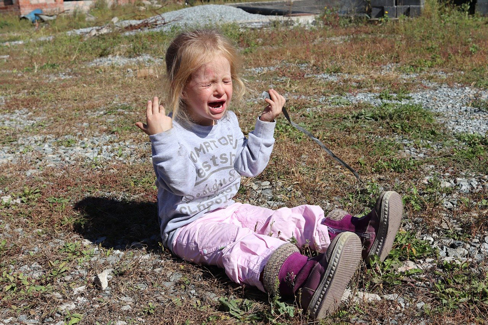 child sitting on the ground having a meltdown