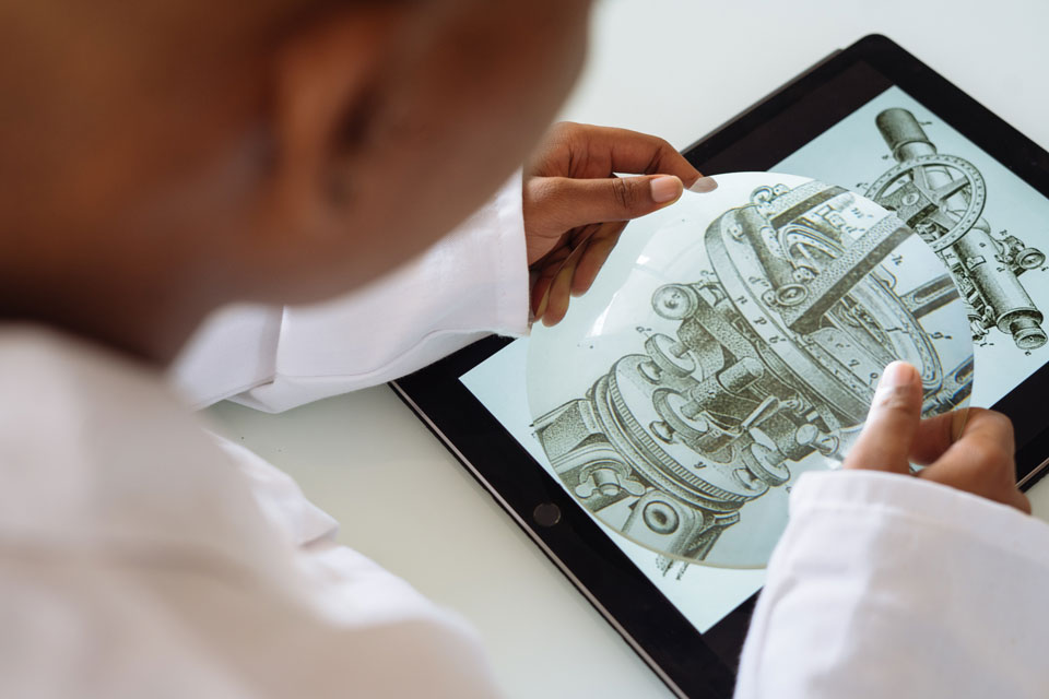 Young person looking at the structure of a mediaeval telescope on an ipad