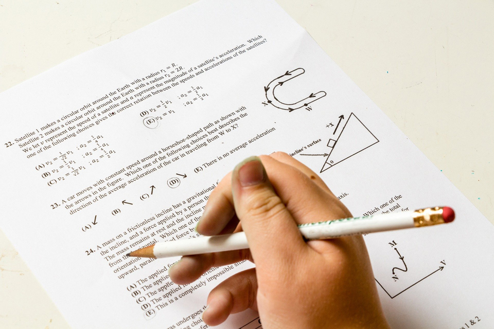 Photo of a hand with a pencil marking some work