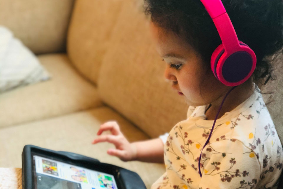 Girl in headphones looking at an ipad