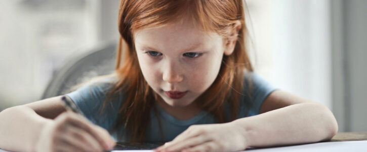 young girl writing in a book