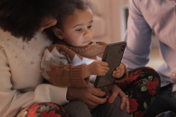 Toddler reading a mobile phone