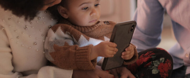 Toddler reading a mobile phone