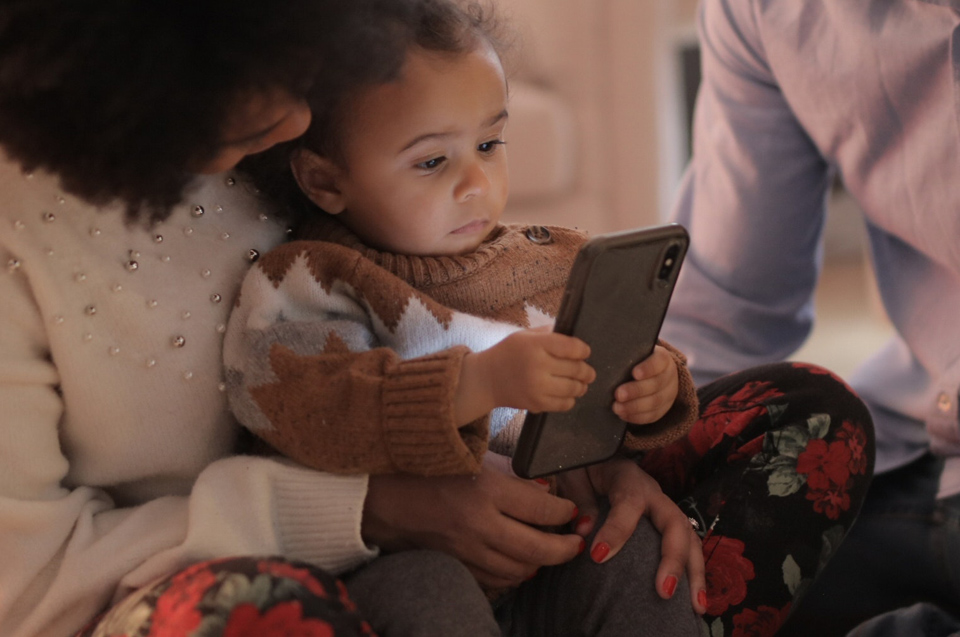 Toddler reading a mobile phone