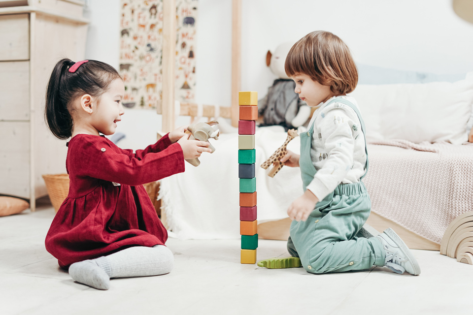 Two pre-scool children playing with bricks