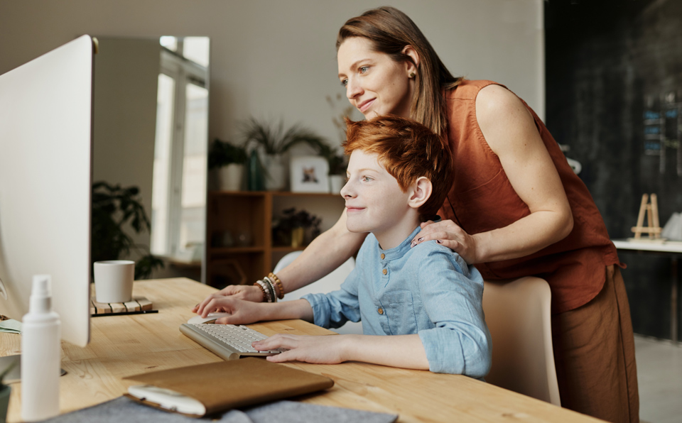 Photo of woman teaching her son while smiling