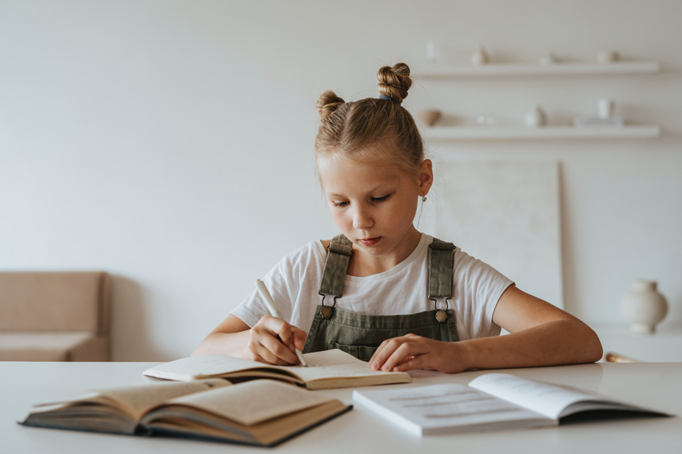 Girl writing revision notes at a table