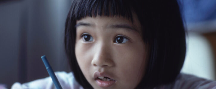 Young child holding a pen