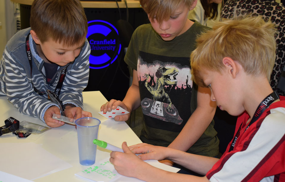 Three young boys working together on an experiment