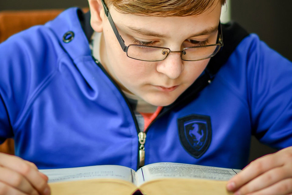 teenage boy studying a book