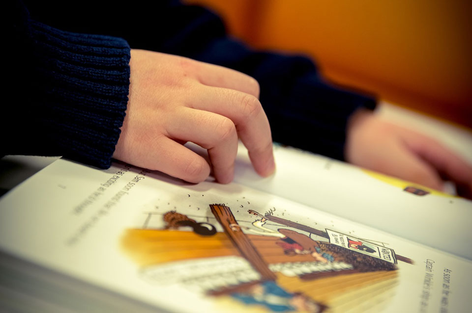 Child's hands resting on an illustrated book