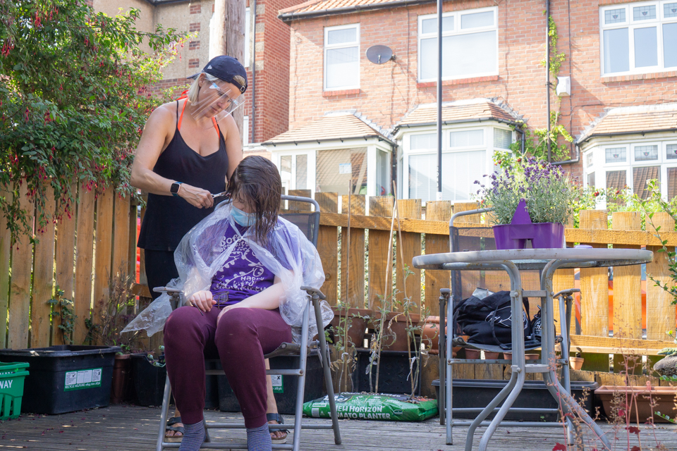 Hair cut in back garden, with one person wearing PPE mask