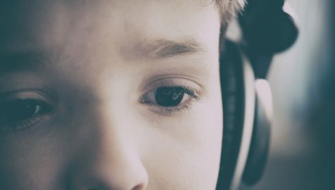 child in headphones looking slightly worried