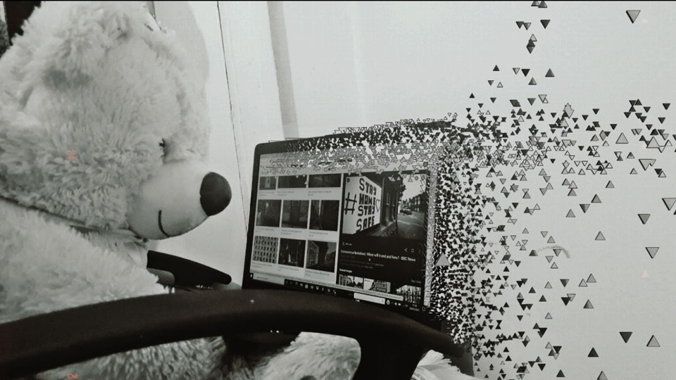 Edited black and white photograph. Cuddly bear sitting in front of a computer screen from which pixels are escaping looking like the virus spreading