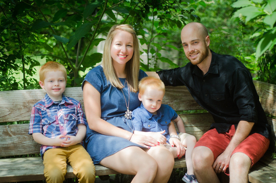 family sitting on a park bench