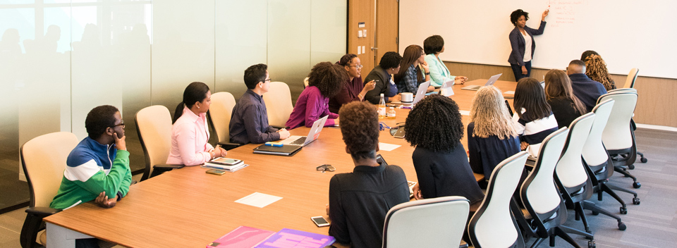 group of people gathered in a meeting room listening to a lecture