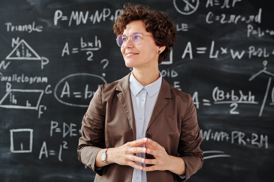 Female teacher in front of blackboard