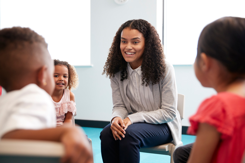 Teachers sitting in a circle with young pupils