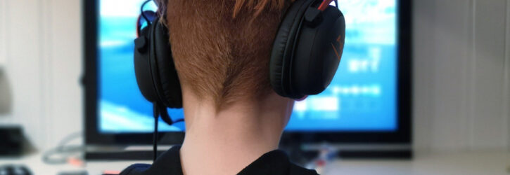 Boy with headphones gaming on computer