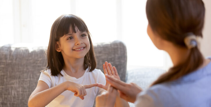 young girl signing to an adult