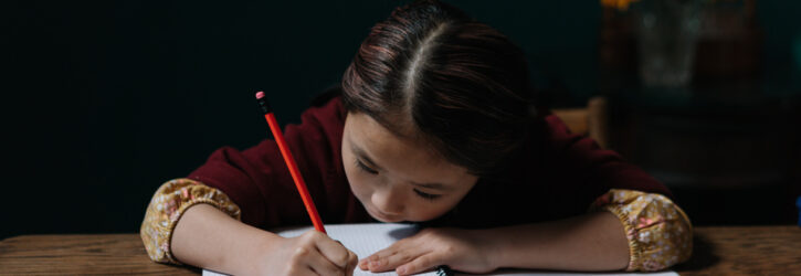 young girl writing in a notebook