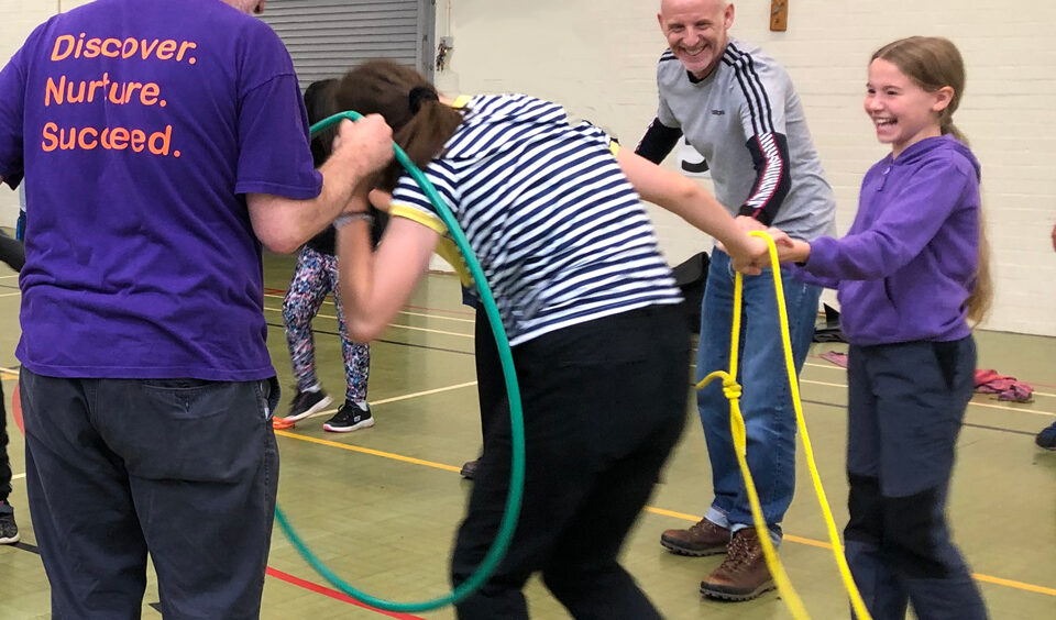 Trying to get through a hoop while holding hands in a circle team game at Lea Green Centre, Let's Explore Day, October 2021
