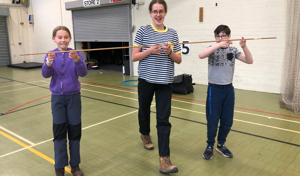 walking as a group with a stick balanced on fingers between the young people at Lea Green Centre, Let's Explore Day, October 2021