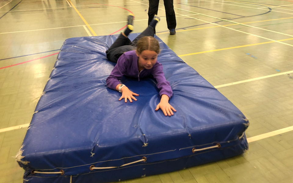 girl surfing the floor on a padded mat at Lea Green Centre, Let's Explore Day, October 2021