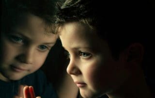 boy looking at his reflection in the window