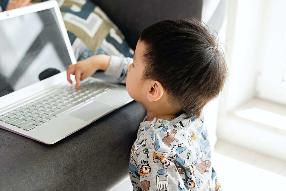 very young child operating a laptop