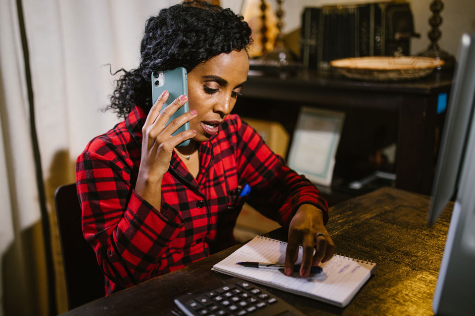 Parent on the phone looking at a list her her desk