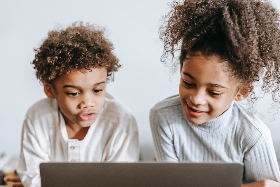 two children looking at a laptop