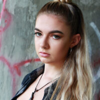 teenage girl standing against a graffiti background