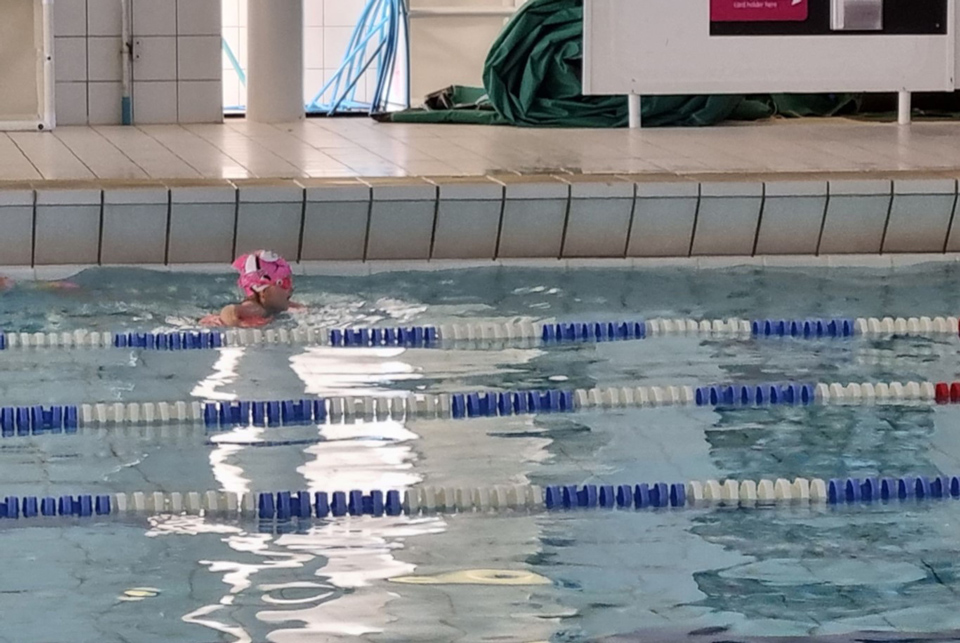 young child swimming in a swimming pool