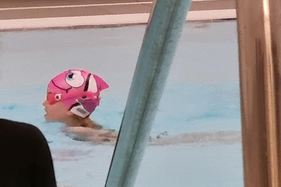 young girl in shark hat swimming
