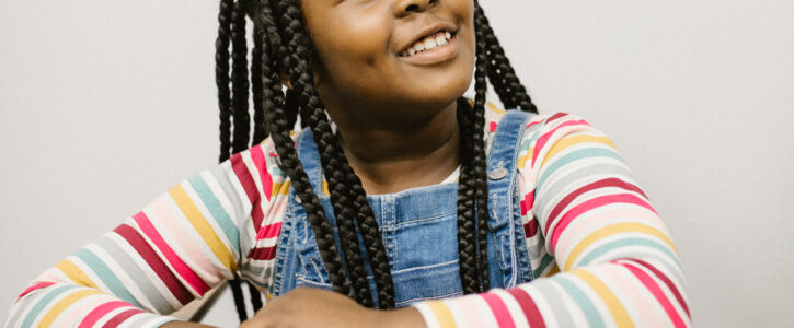 girl at desk looking up, happy