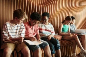 childrensittingonwavyseat Children sitting on a wavybacked seat writing