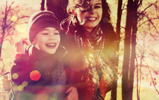 boy and mum laughing in the autumn trees