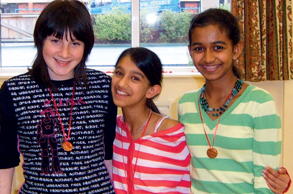 3 girls standing together in a group